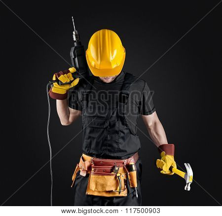 construction worker in helmet with hammer and drill