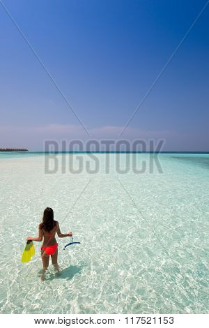 Woman with snorkeling gear looking at the sea
