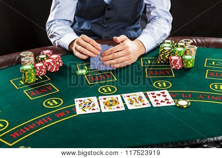 Closeup of poker player with playing cards and chips