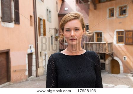 A young woman stands in the middle of the street