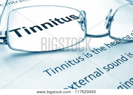 Paper with diagnosis Tinnitus and glasses.