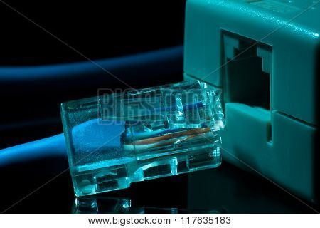Twisted pair (patch cord) blue network Internet cable in blue tones on a black background is inserte