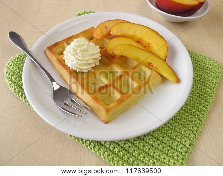 Belgian waffles with peaches and whipped cream