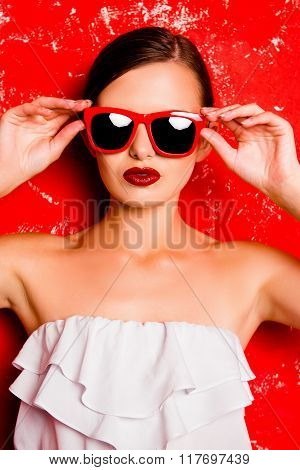 Fashionable Girl Holding The Glasses Against The Red Background