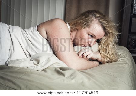 A woman feel sick lying down on bed