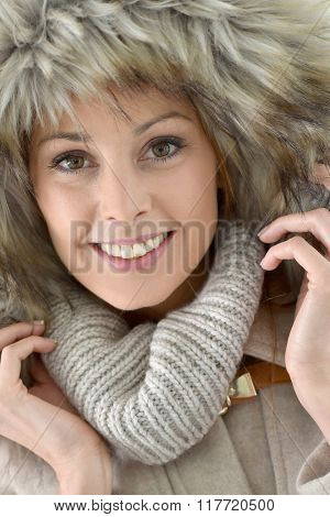 Closeup of woman wearing jacket with fur hood, isolated