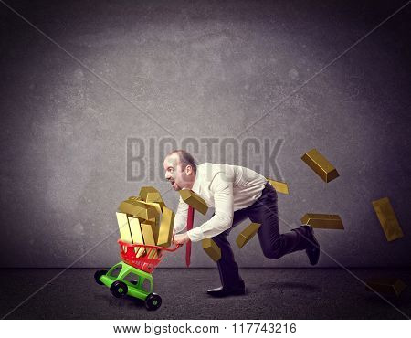 man with shopping troller toy and golden ingot