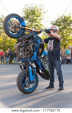 Biker hold motorbike in hands