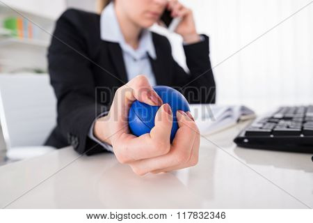 Businesswoman Pressing Stressball At Desk