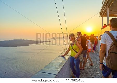 SANTORINI, GREECE - AUGUST 07, 2015: people meet sunset on Santorini island. Santorini, classically Thera, and officially Thira, is an island in the southern Aegean Sea