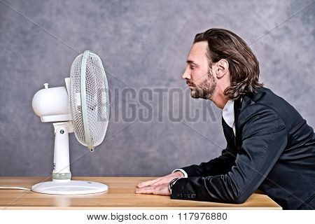 Business Man In Dark Suit Sitting In Front Of Ventilator