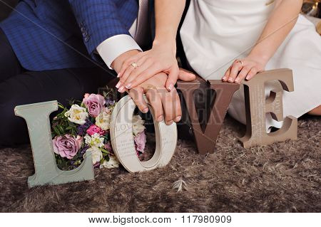 Vintage wooden inscription Love and hands of just married couple.