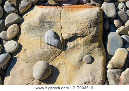boulders and colorful pebbles on the beach on a warm summer day