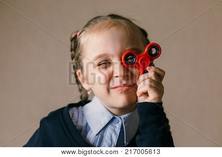 Little caucasian girl with Fidget Spinner held up to his eyes