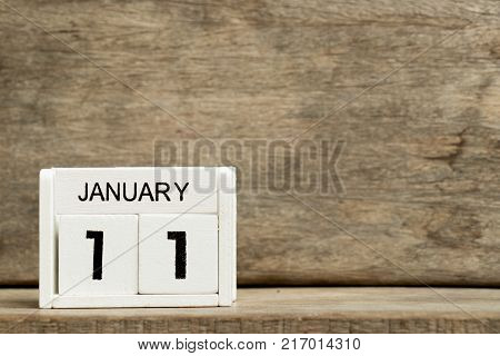 White block calendar present date 11 and month January on wood background