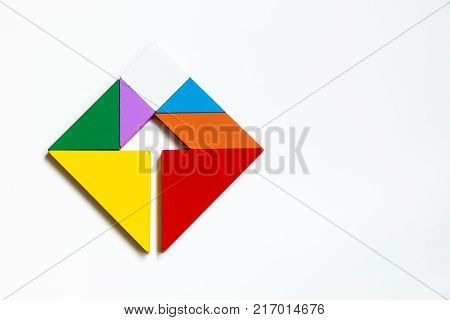Colorwood tangram puzzle on square with arrow sign shape on white background (Concept of Business direction company vision or target)