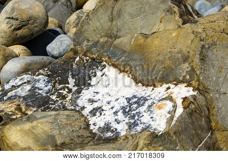 boulders and colorful pebbles on the beach on a warm summer day