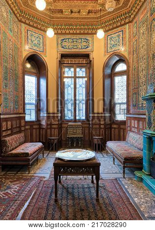 Cairo Egypt - December 2 2017: Manial Palace of Prince Mohammed Ali. Winter room at the Residence Hall with ornate wall and ceiling windows decorated couches tea tables and ornate carpet