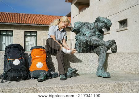 VALGA, SPAIN - SEPTEMBER 10, 2017: Pilgrim with injured foot in front of the pilgrim hostel of Valga on the Camino de Santiago trail on September 10, 2017 in Galicia, Spain