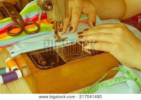 closeup of woman hands sewing yellow cloth outdoors. Woman's Hand Sewing Quilt