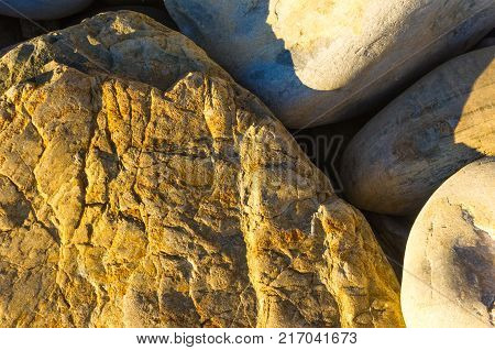 boulders and colorful pebbles on the beach on a warm summer day