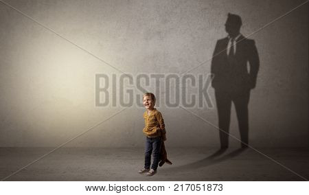 Little boy imagine that he will be businessman and illustrating his future in a big shadow