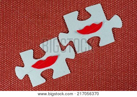Close-up of two parts of a puzzle. Symbolic women with lips. The concept of psychological compatibility, friendship.
