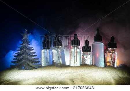 Electronic Cigarette With Vape Liquids And Christmas Decorations On Bokeh Lights Background