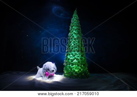 Toy Dog - A Symbol Of The New Year Under The Snow Against The Background Of Fir Branches. Toy's Dog 