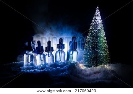 Electronic Cigarette With Vape Liquids And Christmas Decorations On Bokeh Lights Background