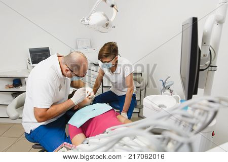 Close Up Process Of Preparing And Installing Dental Ceramic Crown. Male Professional Dentist Helps T