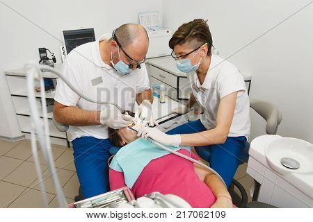 Close Up Process Of Preparing And Installing Dental Ceramic Crown. Male Professional Dentist Helps T