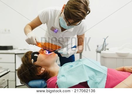 Close Up Process Of Preparing And Installing Dental Ceramic Crown. Male Professional Dentist Helps T