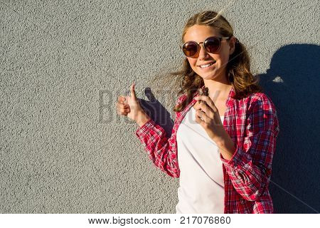 Portrait of beauty teen model girl holding chocolate bar and showing thumbs up. Thumb up energy and joy