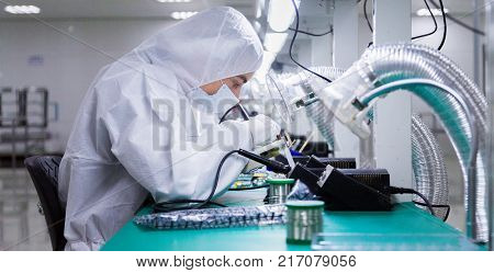 people in white isolating costumes working in laboratory
