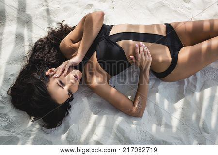 Beautiful young girl in a sexy black swimsuit in paradise islands