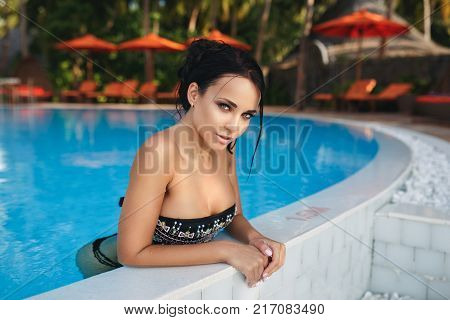 Beautiful young girl in a sexy swimsuit in a pool
