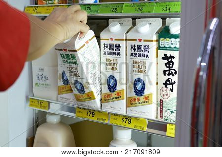 Taipei, Taiwan - October 19, 2017 : Woman selecting milk in grocery store diary and forzen department