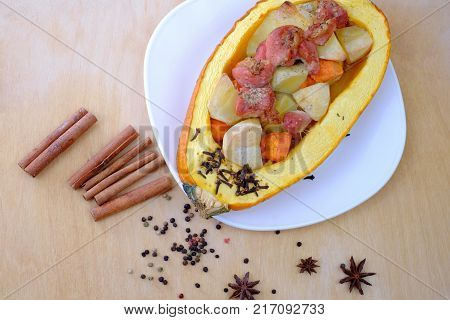 Stew with meat vegetables cinnamon anise and spices baked in pumpkin. Christmas concept.