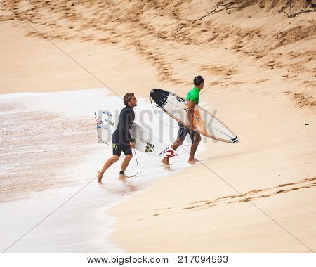 SUNSET BEACH HAWAII USA - DECEMBER 2, 2017: Competitive surfers walking on beach at the 2017 Vans World Cup of Surfing competition at Sunset Beach on Oahu's scenic North Shore. This is the second of three surfing competitions and Conner Coffin took first 
