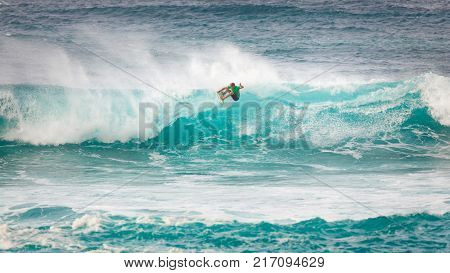 SUNSET BEACH HAWAII USA - DECEMBER 2, 2017: Competitive surfer at the 2017 Vans World Cup of Surfing competition at Sunset Beach on Oahu's scenic North Shore. This is the second of three surfing competitions and Conner Coffin took first place.