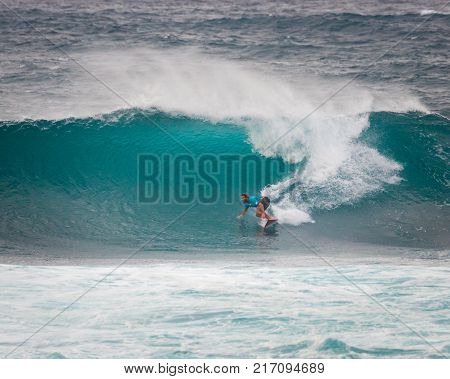 SUNSET BEACH HAWAII USA - DECEMBER 2: Competitive surfers walking on beach at the 2017 Vans World Cup of Surfing competition at Sunset Beach on Oahu's scenic North Shore. This is the second of three surfing competitions and Conner Coffin took first place.
