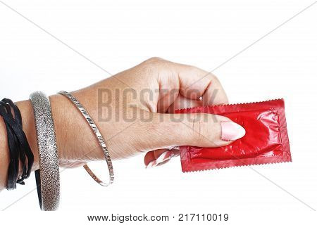 Woman hand holding condom on isolated white cutout background. Studio photo with studio lighting easy to use for every concept. STD.