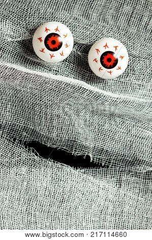 Red eyes and white bandages on black. Background of the face of the mummy for Halloween for the design of invitations, posters and so on.