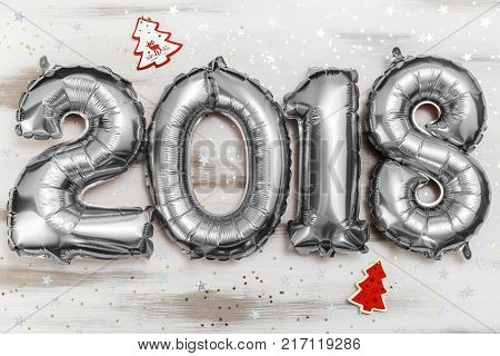Bright silver balloons figures 2018, New Year Balloons with glitter stars on white wood table background. Christmas and new year celebration