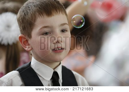 Belarus Gomel June 3 2016 . Graduation in the kindergarten.A child looks at a soap bubble.An admiring look. To see a miracle. To admire the beauty.