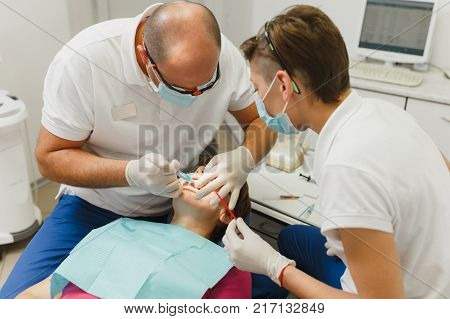 Process Of Preparing And Installing Dental Ceramic Crown. Professional Dentist And Assistant, Lookin