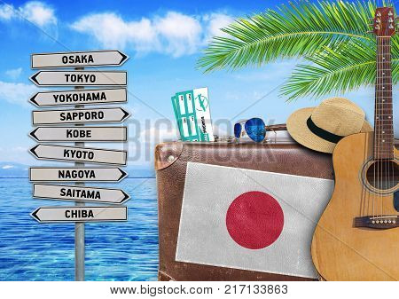 Concept of summer traveling with old suitcase and Japan town sign