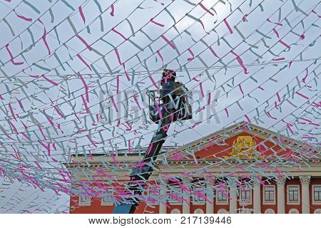 Moscow Russia - February 14 2017: Worker decorates Tverskaya Square with colorful ribbons for Russian national festival 