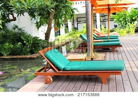 Cozy daybed with umbrellas by the pool